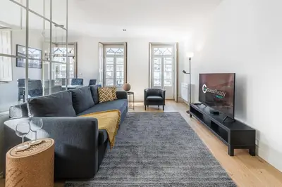 a living room with a couch and a tv at GuestReady - Porto Wine District Penthouse in Vila Nova de Gaia