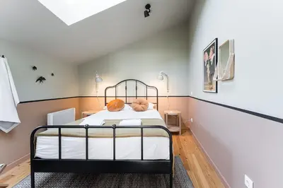 a bedroom with a black bed in a room at GuestReady - Spacious and modern Apt W/ Skylight in Porto