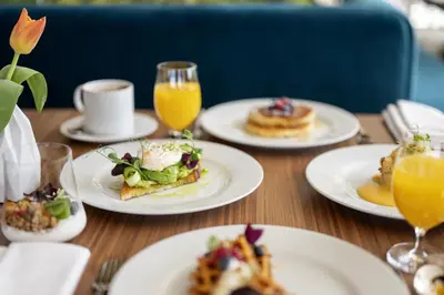 a wooden table topped with plates of food and drinks at Renaissance Porto Lapa Hotel in Porto