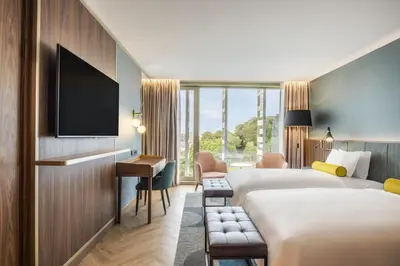 a hotel room with a bed and a flat screen tv at Renaissance Porto Lapa Hotel in Porto