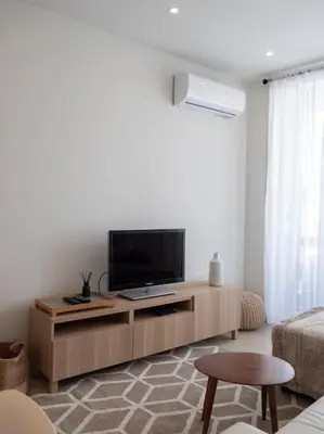 a living room with a flat screen tv on a cabinet at APOSENTUS - Charming Torrinha in Porto