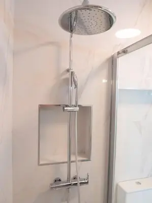 a shower head in a bathroom with a mirror at APOSENTUS - Charming Torrinha in Porto