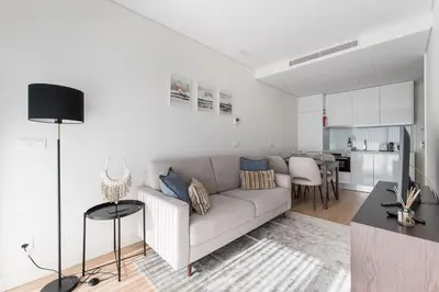a white living room with a couch and a table at GuestReady - Ideal stay near Estádio do Dragão in Porto