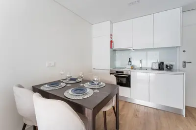 a kitchen with a wooden table with chairs and a dining room at GuestReady - Ideal stay near Estádio do Dragão in Porto