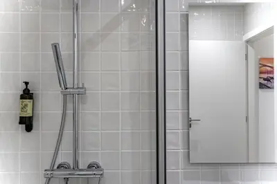 a shower with a glass door and a mirror at Lovely Balcony Porto Downtown in Porto