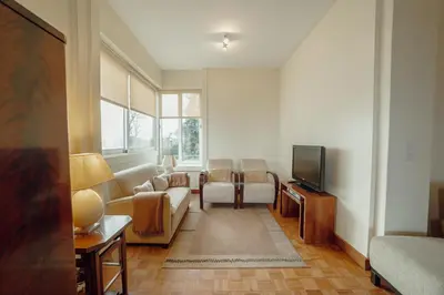 a living room with a couch and a tv at Grand Botanic Garden Apartment by Vacationy in Porto