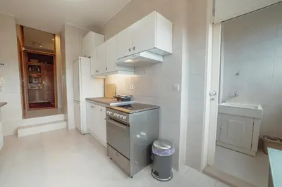 a kitchen with white cabinets and a sink and a stove at Grand Botanic Garden Apartment by Vacationy in Porto