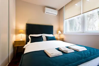 a bedroom with a large bed with blue and white at Aposentus - Your home in Porto in Porto