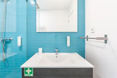a bathroom with a white sink and blue tiles at Dream On - Clérigos Lofts in Porto