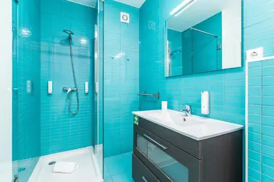 a blue bathroom with a sink and a shower at Dream On - Clérigos Lofts in Porto