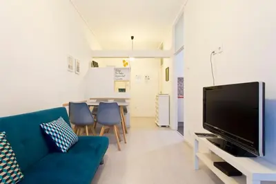 a living room with a blue couch and a tv at Aposentus - Breiner Apartment in Porto