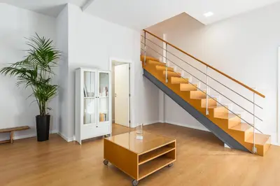 a staircase in a living room with a table at Dream On - Almada Lofts in Porto