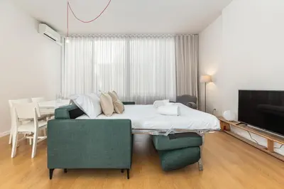 a bedroom with a bed and a couch and a table at Dream On - Almada Lofts in Porto