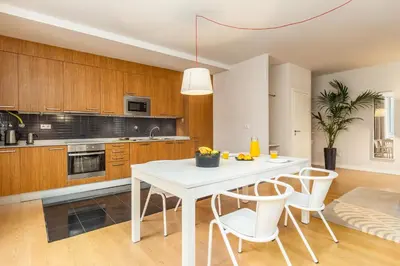 a kitchen with a white table and white chairs at Dream On - Almada Lofts in Porto