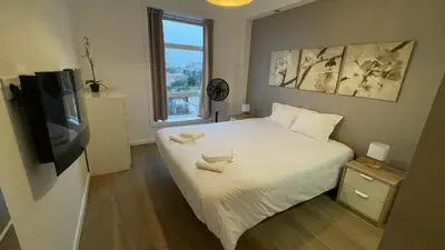 a bedroom with a bed with a tv and a window at HEART OF THE CITY 2! in Vila Nova de Gaia