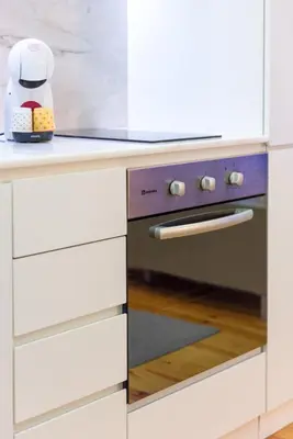 a kitchen with white cabinets and a stove at Casa Barros - Trindade in Porto
