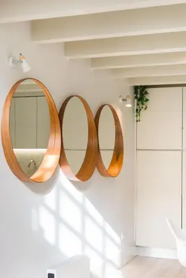 a bathroom with three mirrors hanging on a wall at Casa Barros - Miragaia in Porto