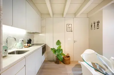 a kitchen with white cabinets and a sink at Casa Barros - Miragaia in Porto