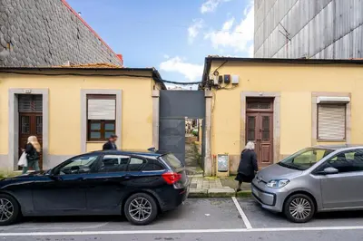 two cars parked in a parking lot next to buildings at WHome Porto City Center Comfort & Stylishly Furnished in Porto