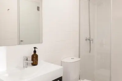 a bathroom with a toilet and a sink and a mirror at VIVA Alameda Suites - River Guest House in Porto