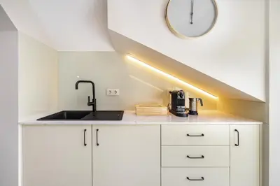 a kitchen with a sink and a clock on the wall at Douro Prestige Urban Retreat with shared S-Pool & Gym in Porto