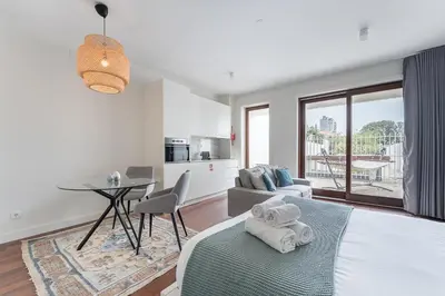 a bedroom with a bed and a table and a kitchen at GuestReady - Almada 516 in Porto