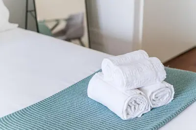 a pile of towels sitting on top of a bed at GuestReady - Almada 516 in Porto