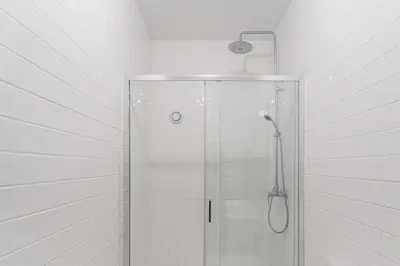 a shower with a glass door in a bathroom at GuestReady - Almada 516 in Porto