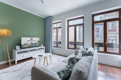 a living room with a couch and two windows at GuestReady - Almada 516 in Porto