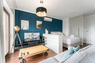 a bedroom with blue walls and a bed and a table at GuestReady - Almada 516 in Porto