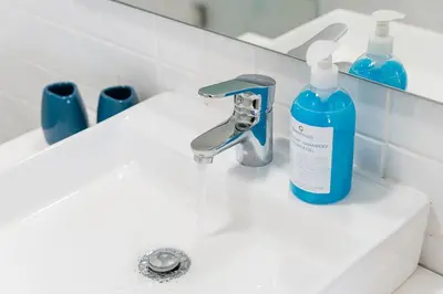 a white bathroom sink with a bottle of soap at GuestReady - Almada 516 in Porto
