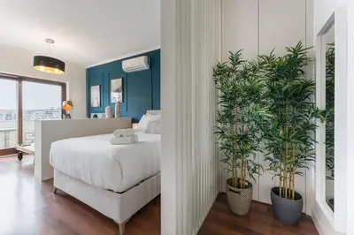 a bedroom with a bed and two potted plants at GuestReady - Almada 516 in Porto