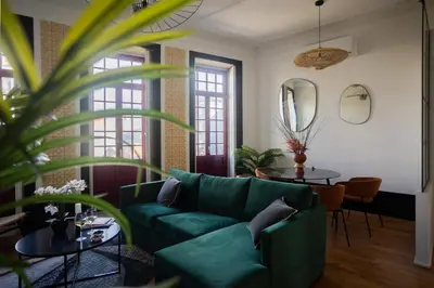 a living room with a green couch and a table at Amazing Family Flat in Center Porto in Porto