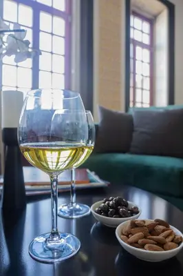 a table with a glass of wine and a bowl of nuts at Amazing Family Flat in Center Porto in Porto