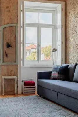 a living room with a blue couch and a window at Ribeira Charming Apartment in Porto