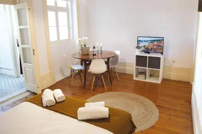 a bedroom with a bed and a table with a tv at InLapa Studio IV Porto Garden View in Porto