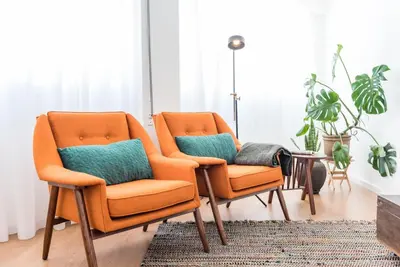 two orange chairs in a living room with a rug at GuestReady - Chic and cozy getaway in Porto
