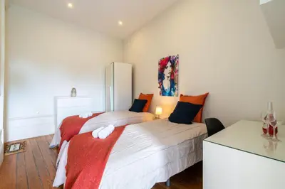 a bedroom with two beds with orange and white at Host Wise - Sweet Bright Flats - City Center in Porto