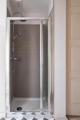 a shower with a glass door in a bathroom at Host Wise - Sweet Bright Flats - City Center in Porto