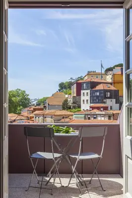 a balcony with two chairs and a view of a city at Timbre Virtudes in Porto