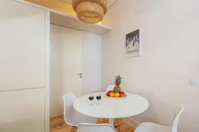 a white dining room with a white table and chairs at Charming T2 by Indulge Porto Flats in Porto