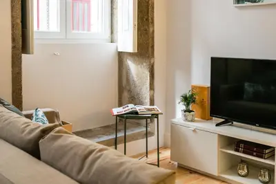 a living room with a couch and a tv at Charming T2 by Indulge Porto Flats in Porto