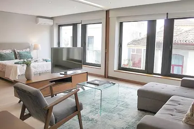 a bedroom with a bed and a television and curtains at Casa do Teatro Oporto Downtown in Porto