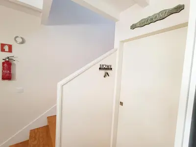 a hallway with a white door with a house sign on it at Duke Street Guest House in Porto