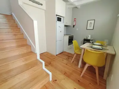 a kitchen and dining room with a table and yellow chairs at Duke Street Guest House in Porto