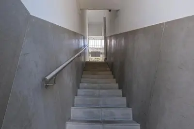 a staircase in a building with a concrete wall at GuestReady - Port Studio 3 in Vila Nova de Gaia
