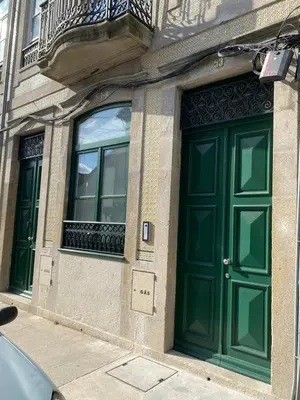 a building with green doors and windows on a street at Villa Invicta 3 in Porto