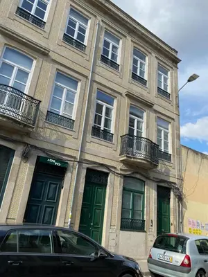 a building with green doors and cars parked in front of it at Villa Invicta 3 in Porto