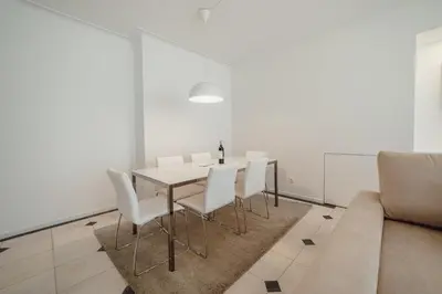 a dining room with a table and chairs and a couch at Grand Premium Boavista Apartment by Vacationy in Porto
