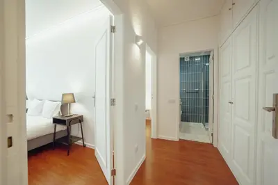 a bedroom with white walls and a bed and a table at Grand Premium Boavista Apartment by Vacationy in Porto